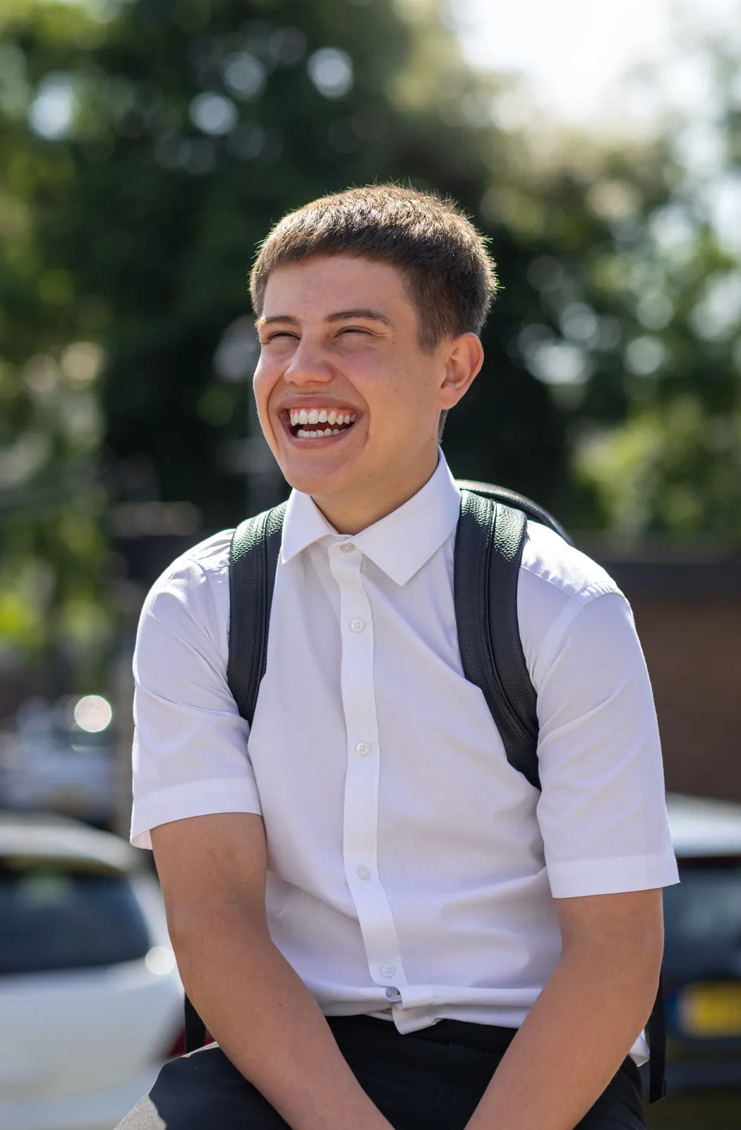 A Vaughan College student laughing outdoors between classes, in uniform