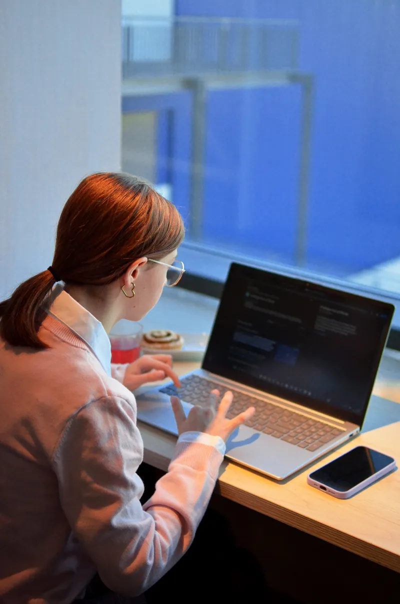 A student writing code on a laptop