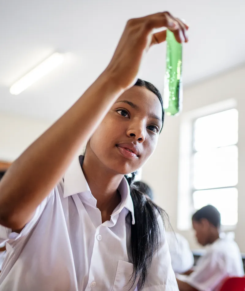 A student examining a test tube in a school science class