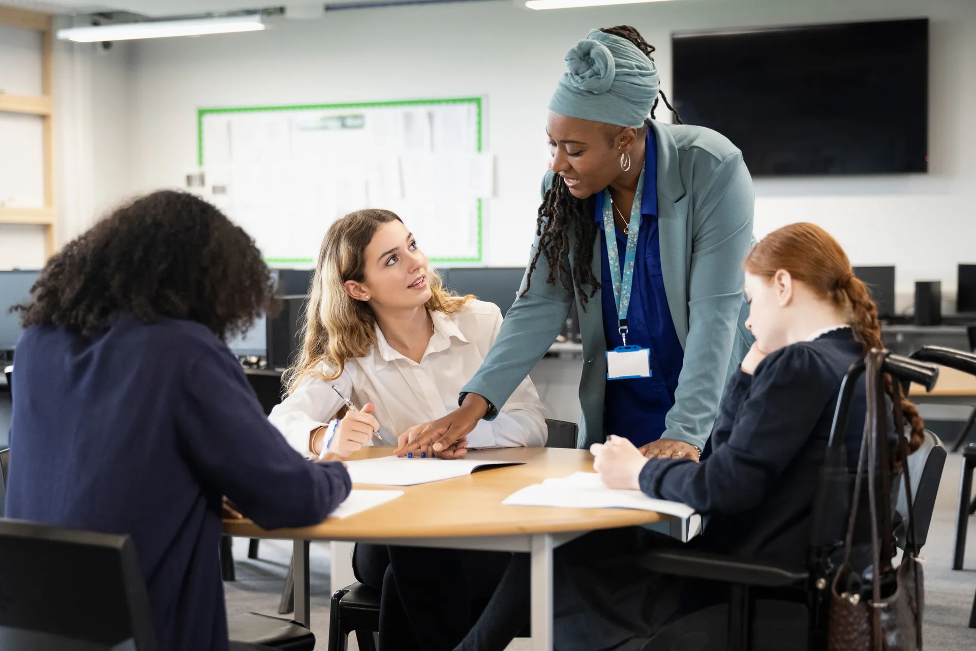 A Vaughan College teacher helping a small group of students with their work