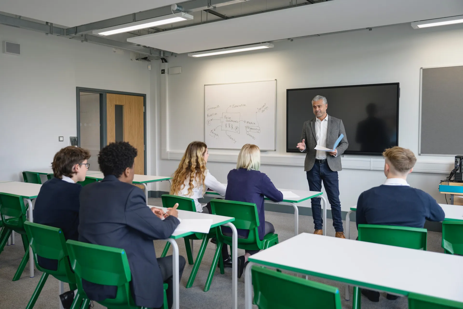 A Vaughan College teacher leading a full senior class from the front of the room
