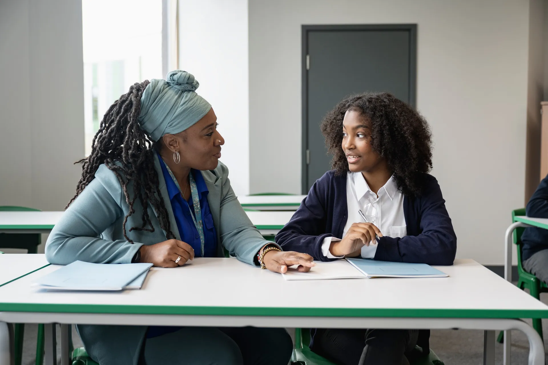 A Vaughan College teacher in a one-on-one guidance conversation with a student at a table